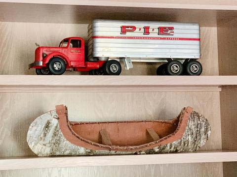 Shelves decorated with vintage red truck and birchbark canoe. 
