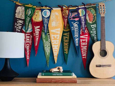 Boys room decorated with a  selection of colorful vintage pennants hung on the wall.