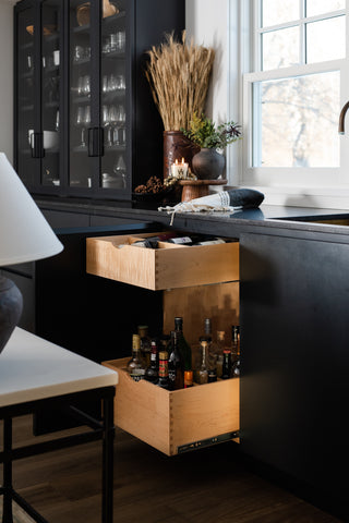 Side view of black bar with two pull out drawers inside a cabinet 