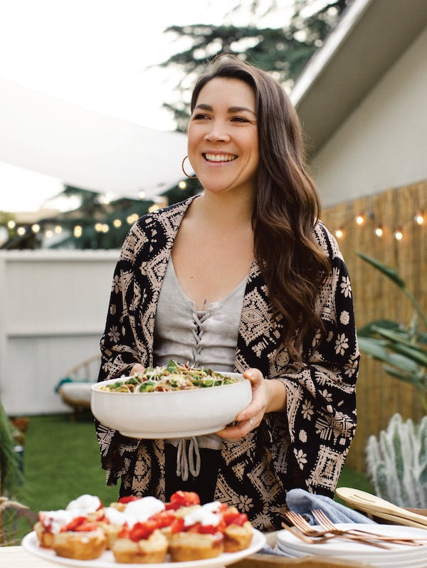 Lauren Toyota for Salt Spring Kitchen Company portrait in the backyard serving a salad and shortcakes