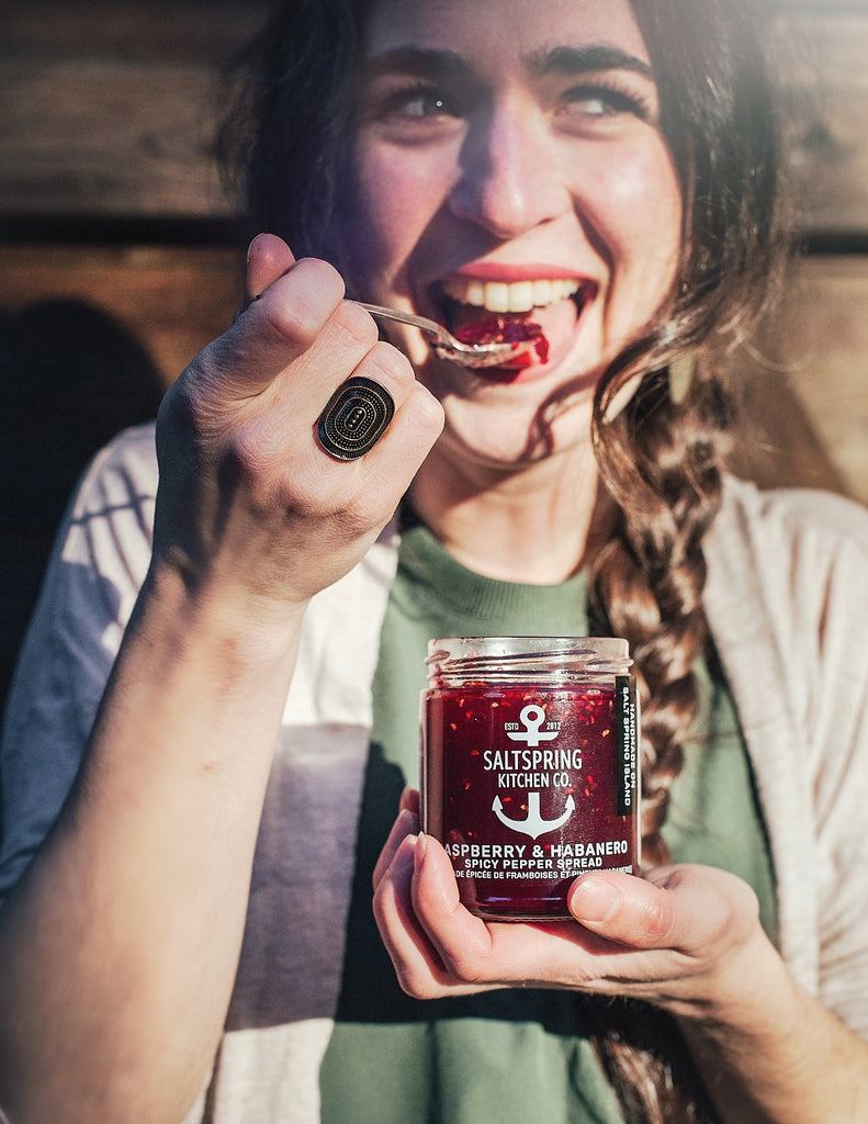 SaltSpring Kitchen Company Mother's Day Gift Guide - A woman eating Raspberry Habanero Spicy Peppe Spread out of the jar