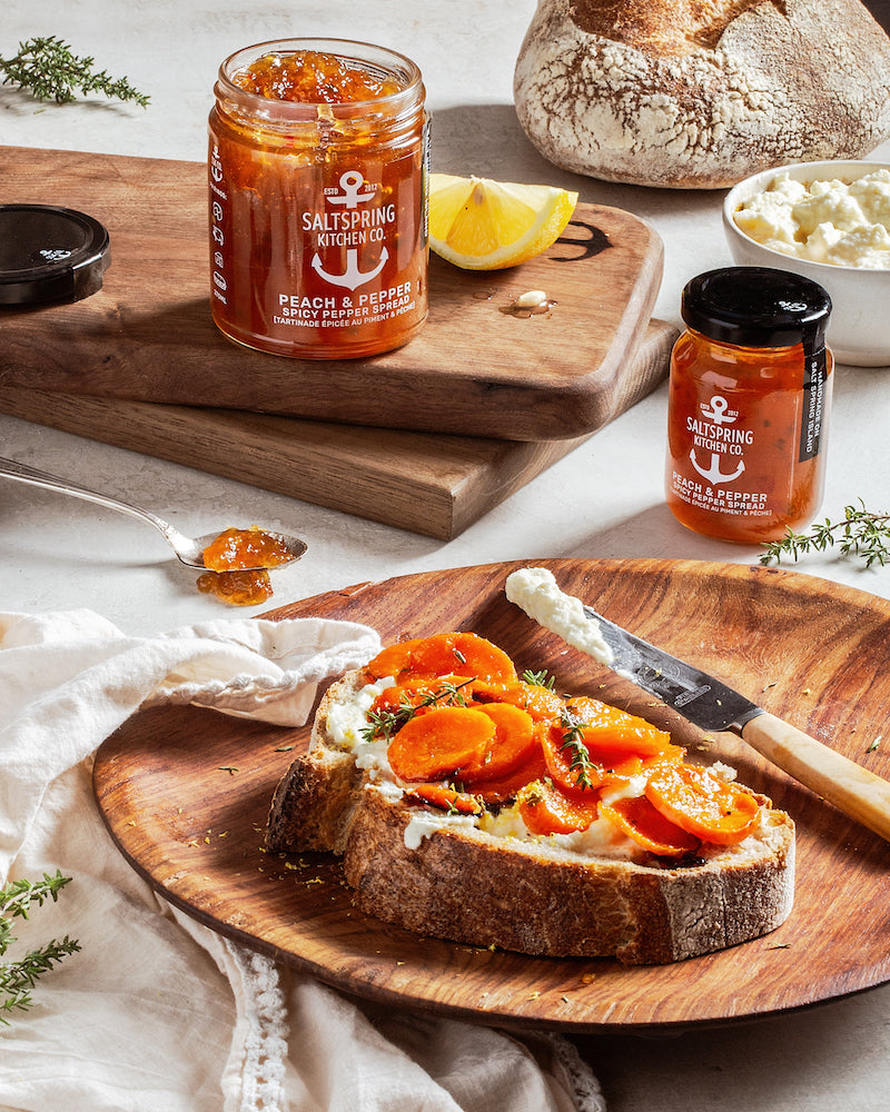 SaltSpring Kitchen Company Spicy Carrot & Feta Tartine on a plate with jars of preserves