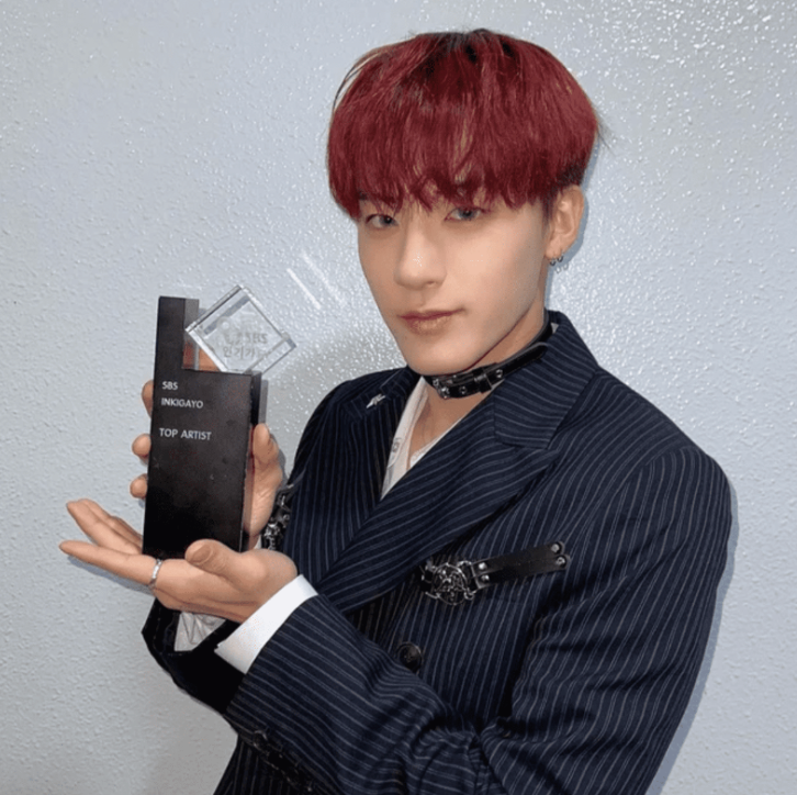 k-pop idol holding a sbs inkigayo music show trophy