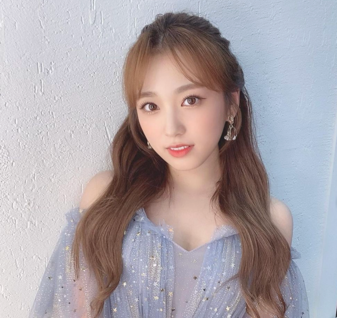 yabuki nako waering blue dress with golden stars in front of white wall