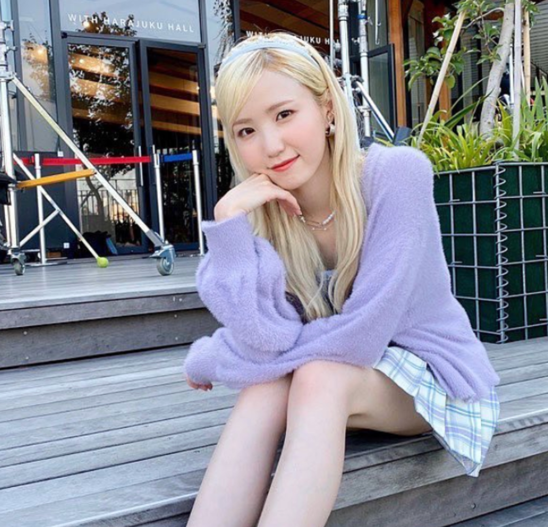 honda hitomi sitting on a bench with blonde hair