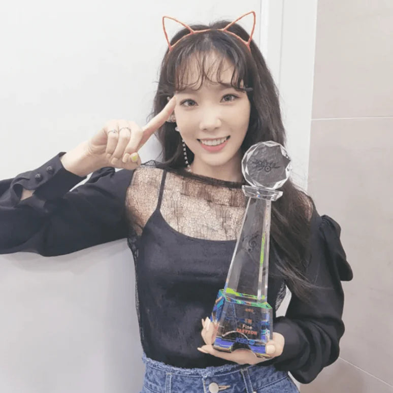 taeyeon holding a music show trophy