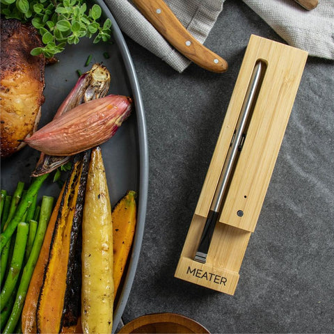 MEATER themometer on table next to vegetables in a pan