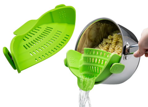 Green strainer that attaches to pot draining water from pasta