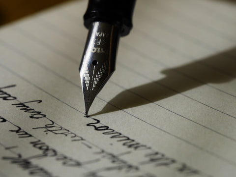 Un stylo qui écris sur une feuille de papier