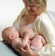 women holding two babies breastfeeding