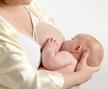 woman holding baby breastfeeding