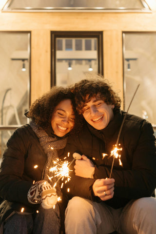 smiling-couple-holding-sparklers