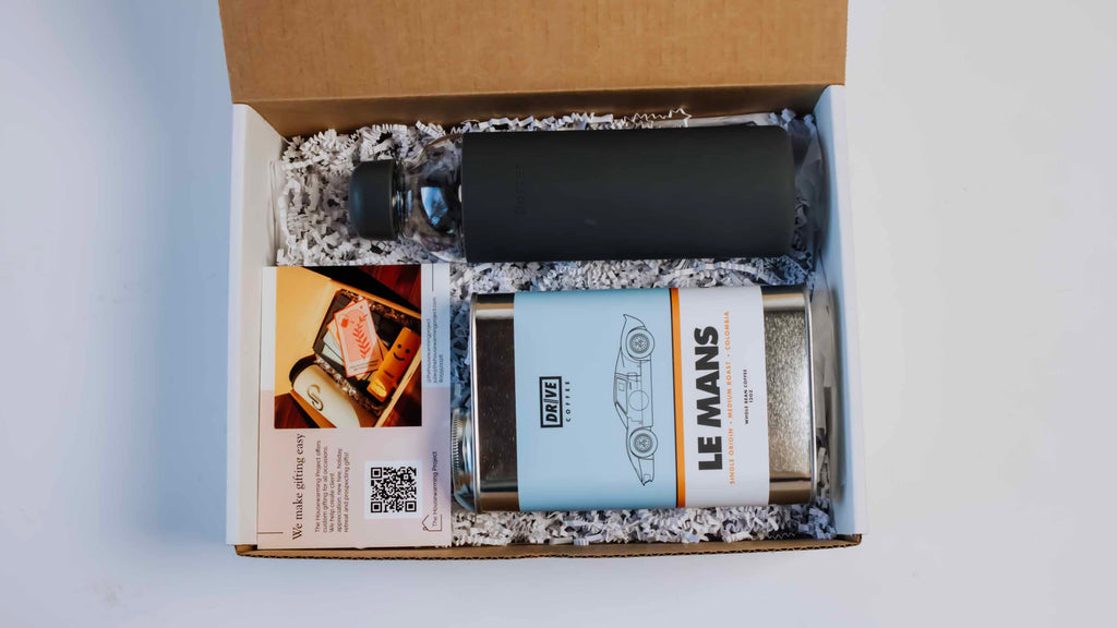 Corporate giftbox with a water botte, a can of  gourmet coffe beans and a card from the house warming project make the perfect gift