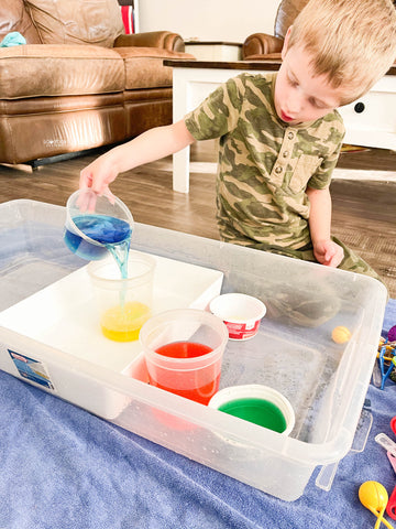 preschool boy pouring colored water - how to encourage independent play