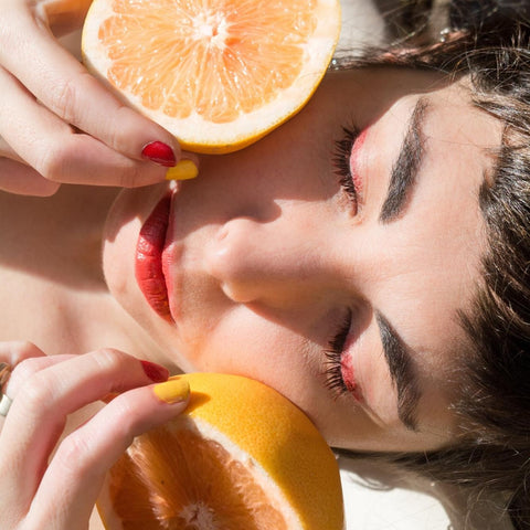 Lady with oranges next to her face
