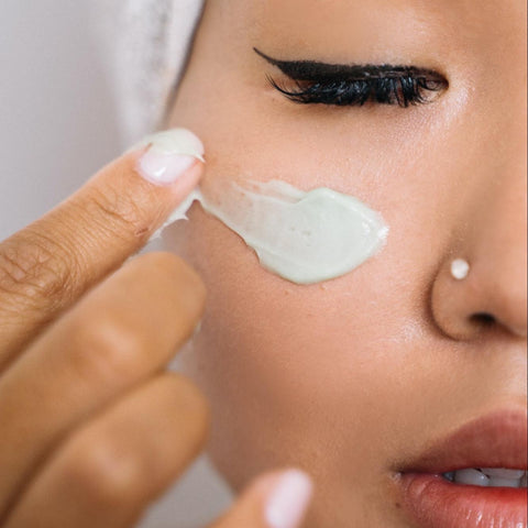 A lady applying eye cream to her face