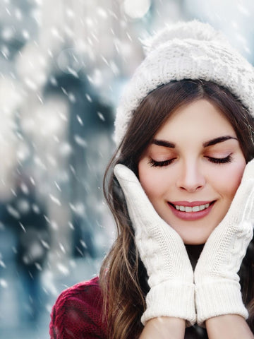 Lady in woolly hat with gloves pressed on her face