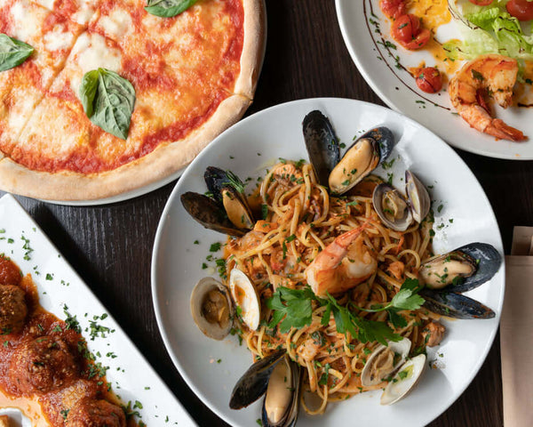 Selection of Italian dishes with shellfish pasta, pizza and meatballs ready for the taking.
