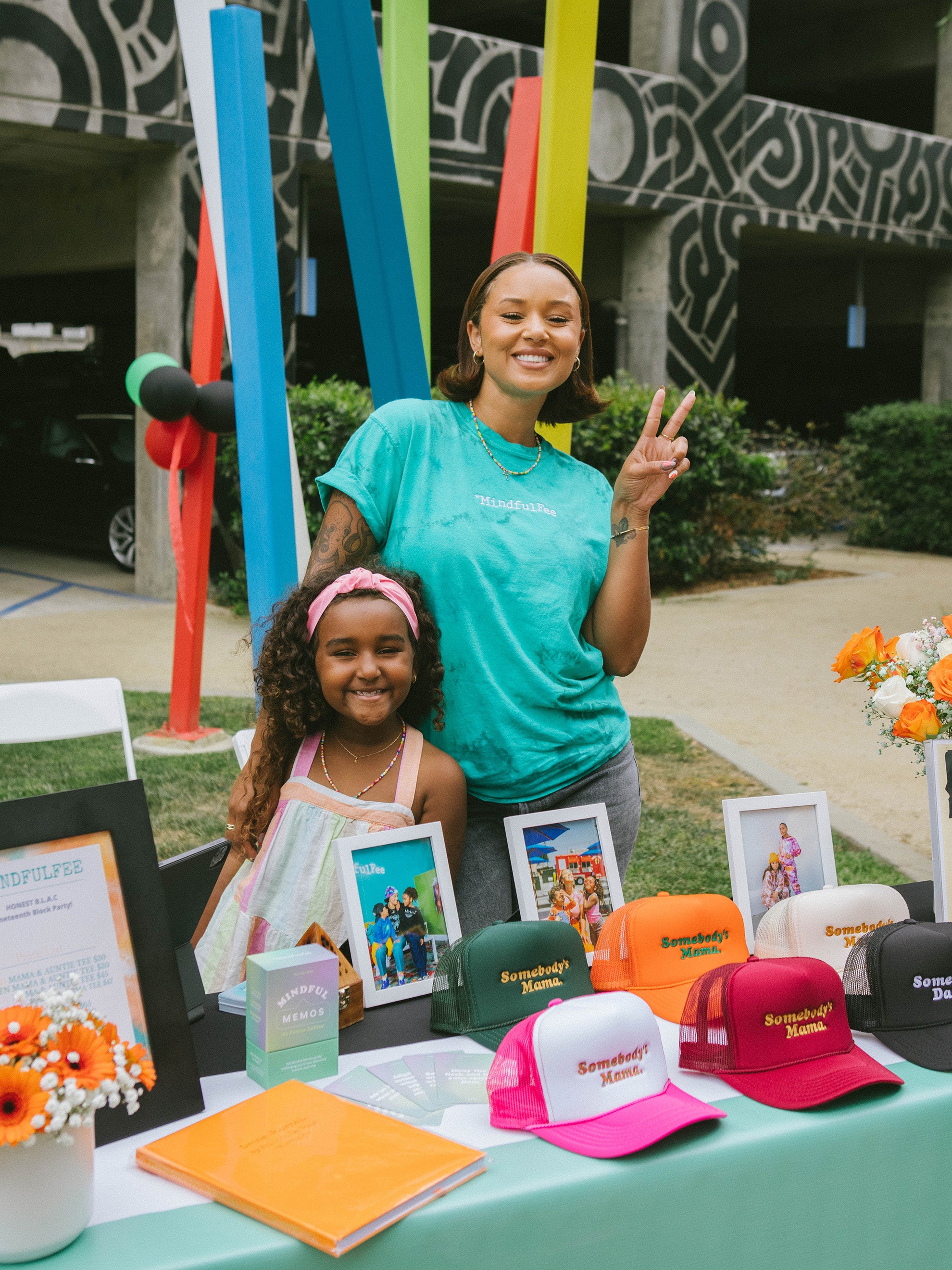 Felicia and Peace standing together behind the MindfulFee table at Honest's B.L.O.C.C. party