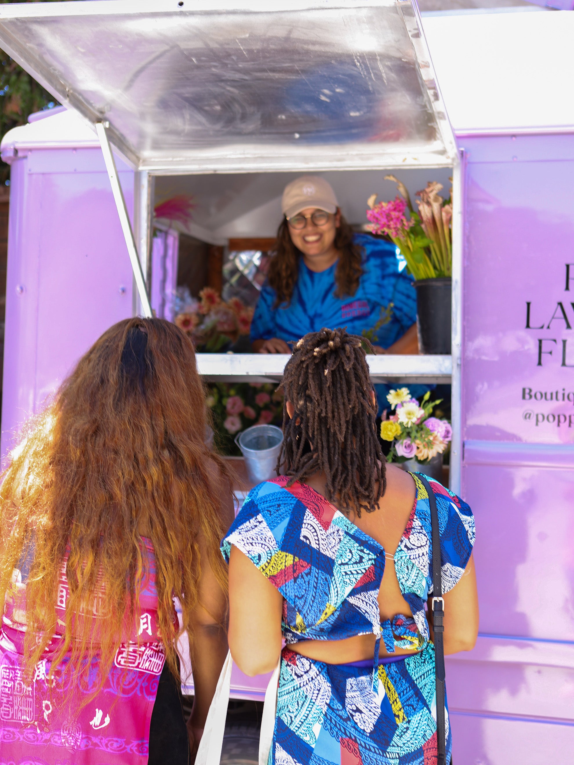 Poppy outside the flower truck talking to 2 Mamas