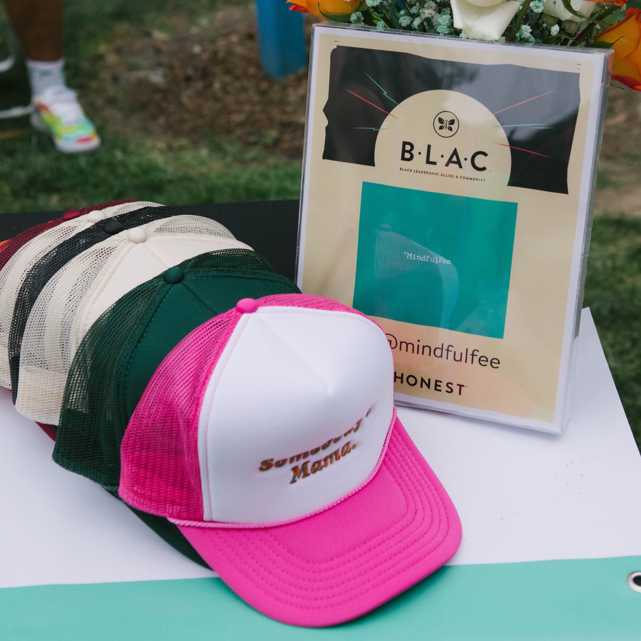 MindfulFee hats next to sign that says Honest's B.L.O.C.C. Juneteenth Party