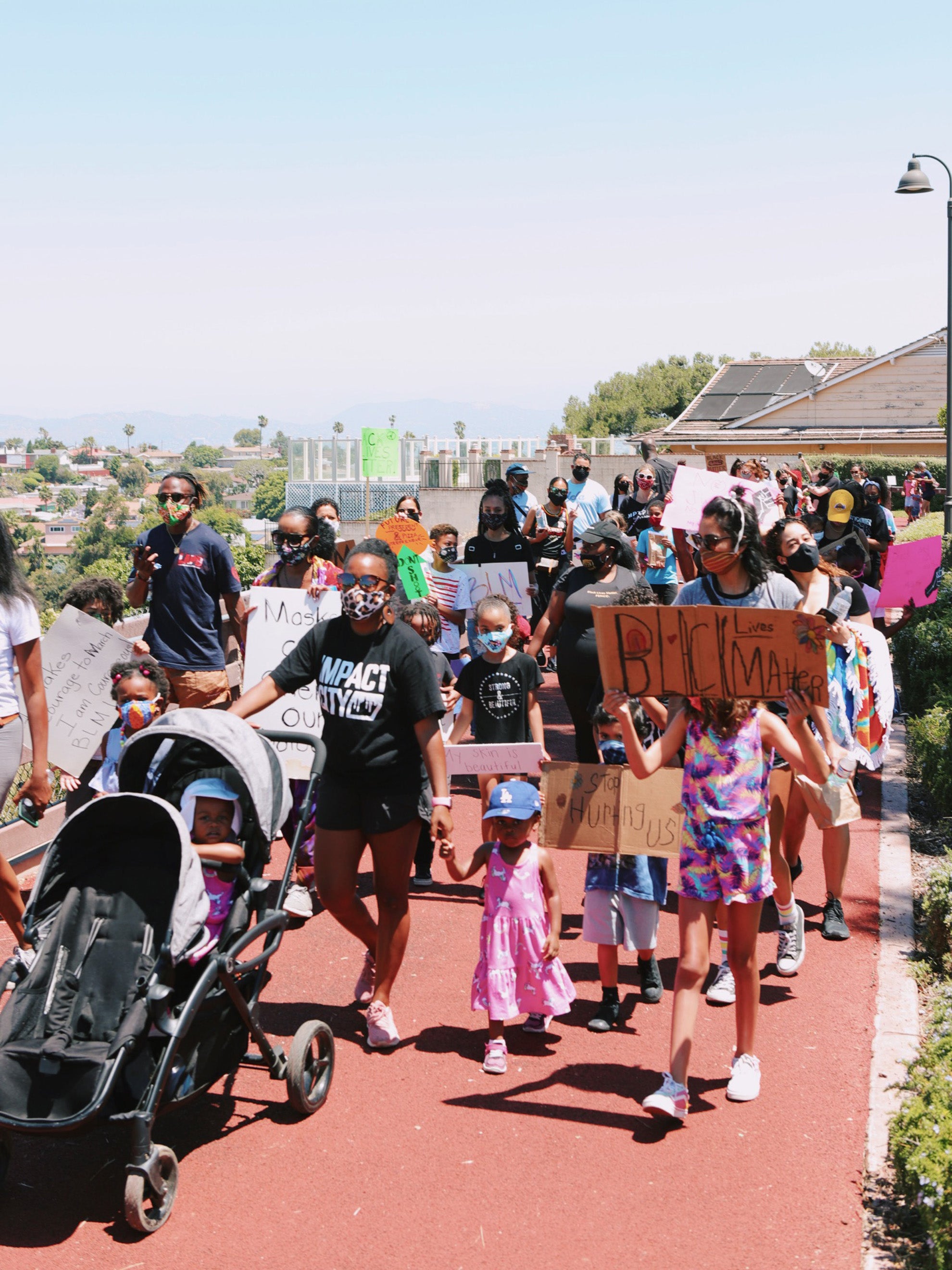 Crowd of families marching with Black Lives Matter posters