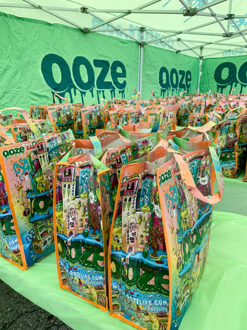 Tables in the green Ooze tent are full of Ooze bags that are filled with Thanksgiving side dishes to be donated for Oozegiving.
