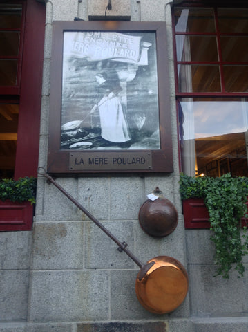 The framed image of Madame Poulard outside the La Mere Poulard's restaurant in Normandy, France.