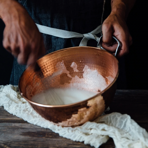 Whisking egg whites by hand copper mixing bowls
