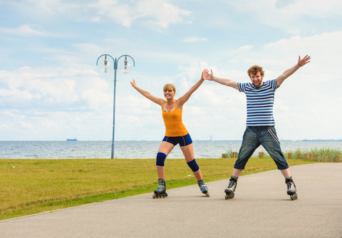 couple rollerblading holding hands
