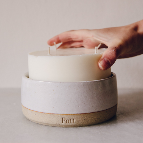 A grand refill candle being placed into ceramic Pott - Home fragrance