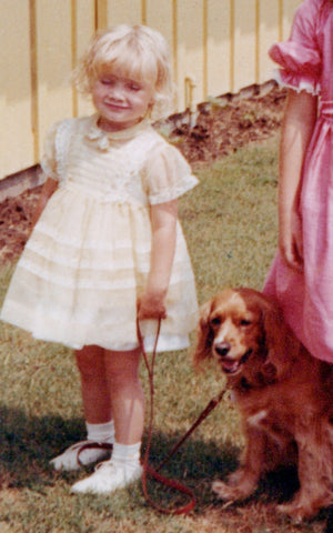 Small girl holding a dog on leash