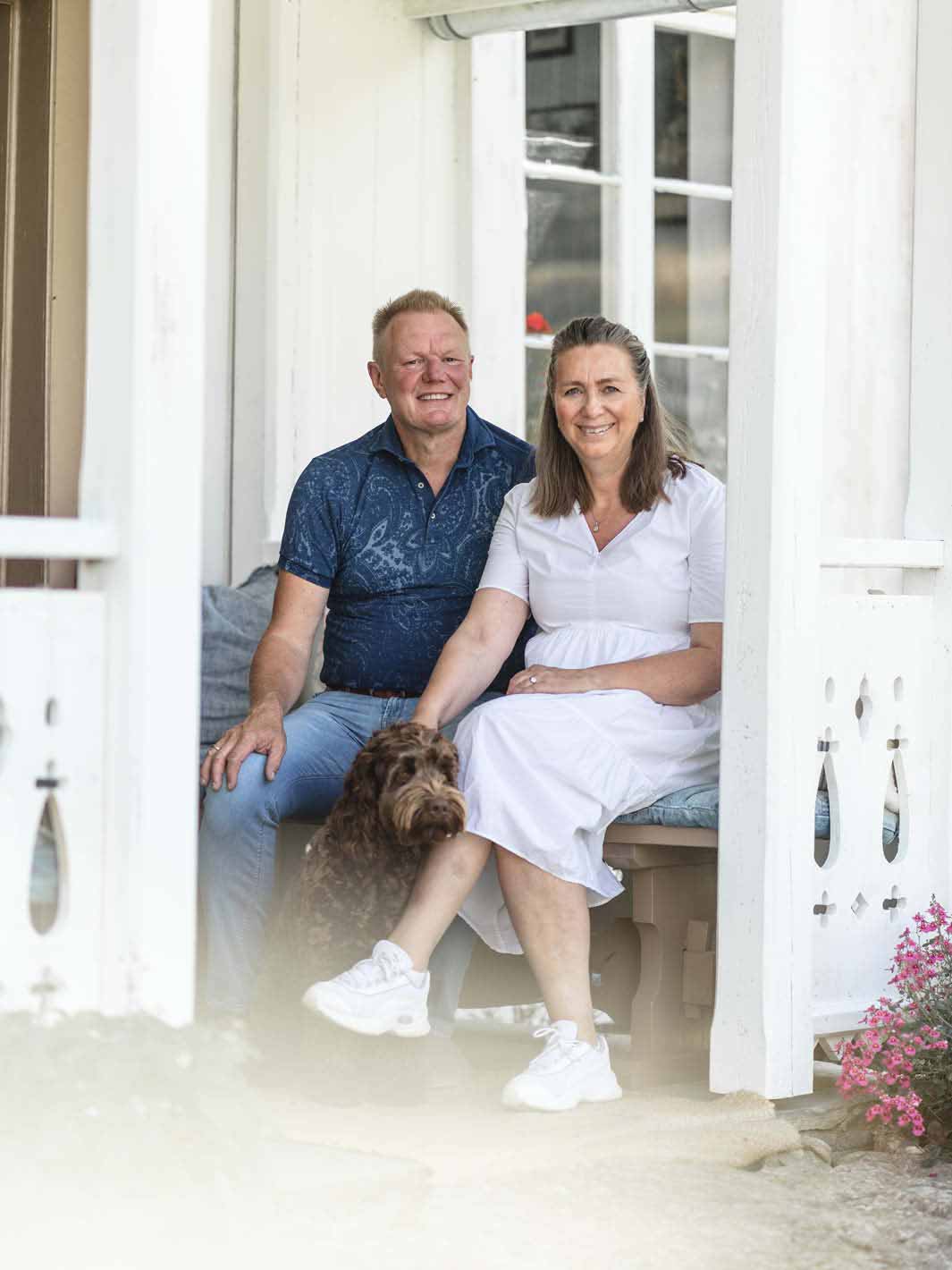 Lars og Marianne med hunden Bella ved inngangen til våningshuset.