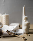 Sculptural Candles on workbench with Quietude Candle labels and wick trimmer