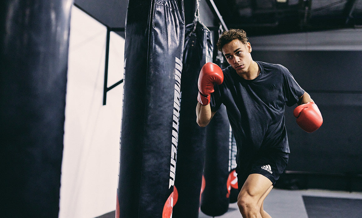 David Nyika punching boxing bag in boxing gym