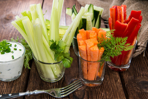 vegetables cut into stick form sitting inside glass cups on a table