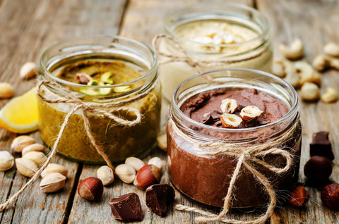 Nut butters in jars on a table. 