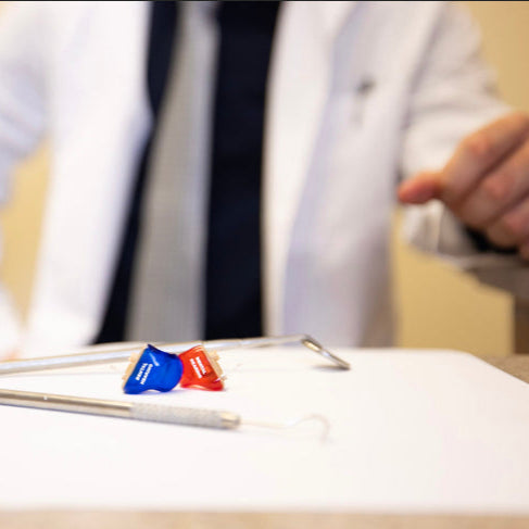 Dentist reaching for Tactical Hearing device