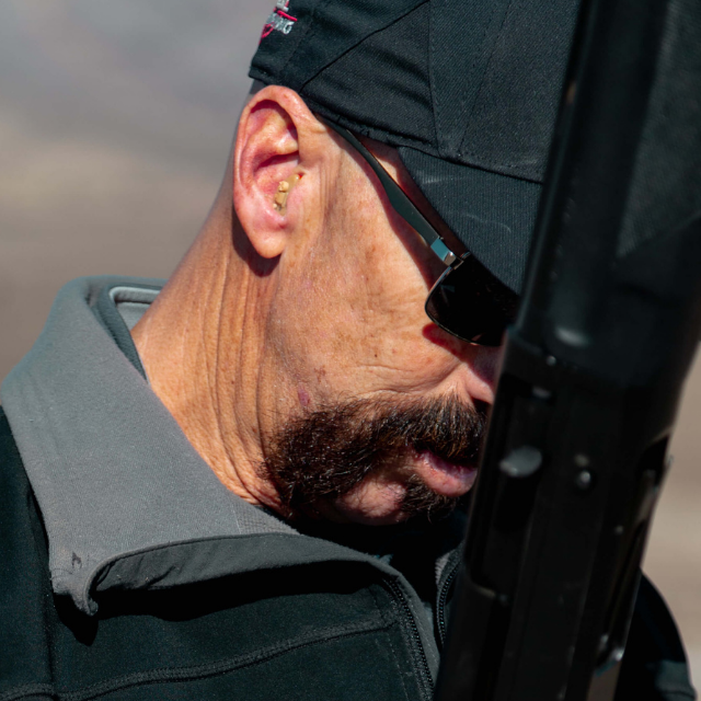 Man wearing Tactical Hearing and holding a shotgun