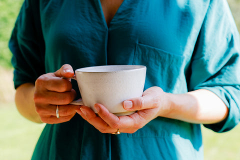 handmade pottery mug in hands