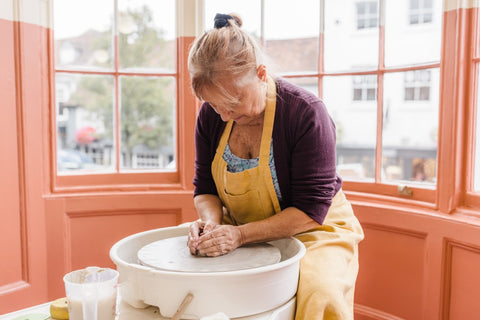 woman throwing pots on the pottery wheel