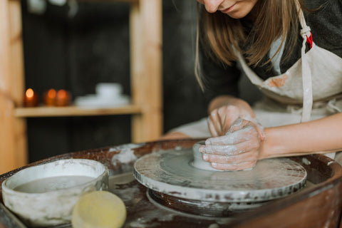 woman making pottery on the wheel