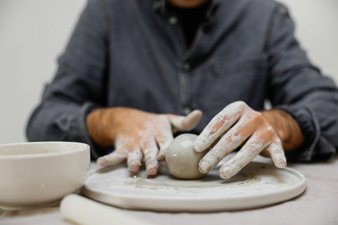 person rolling clay and playing with clay