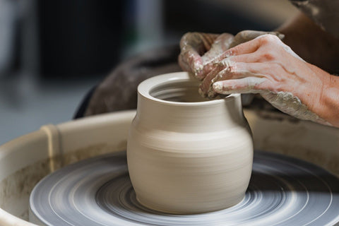 pottery throwing clay on pottery wheel