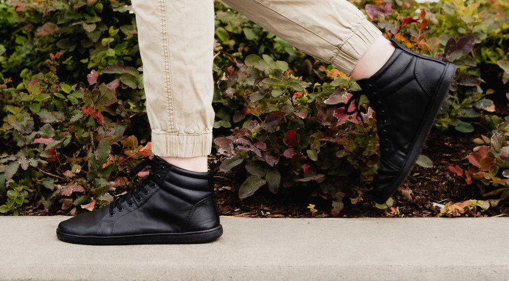 Person wearing black hightop barefoot sneakers model Highrise from brand Feelgrounds