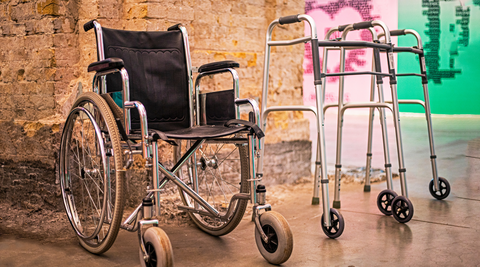 A wheelchair and rollator standing side by side.