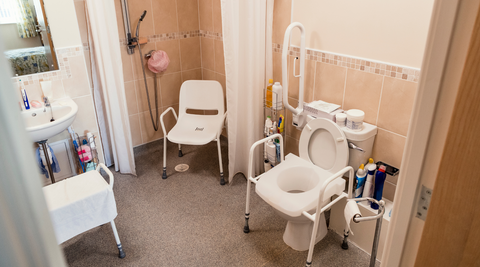 A bathroom with various safety measures installed to help the elderly.