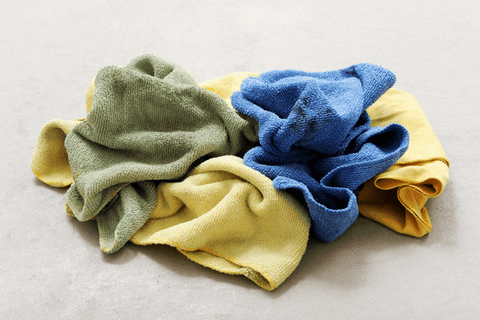 a pile of yellow, blue and green cloths