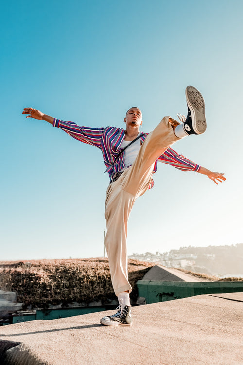 A man standing on one foot on a ledge