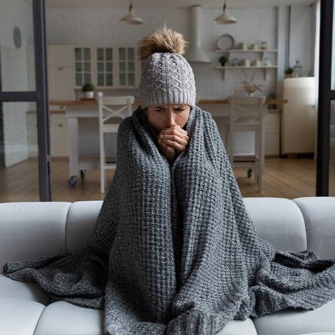 Woman in living room wearing a blanket